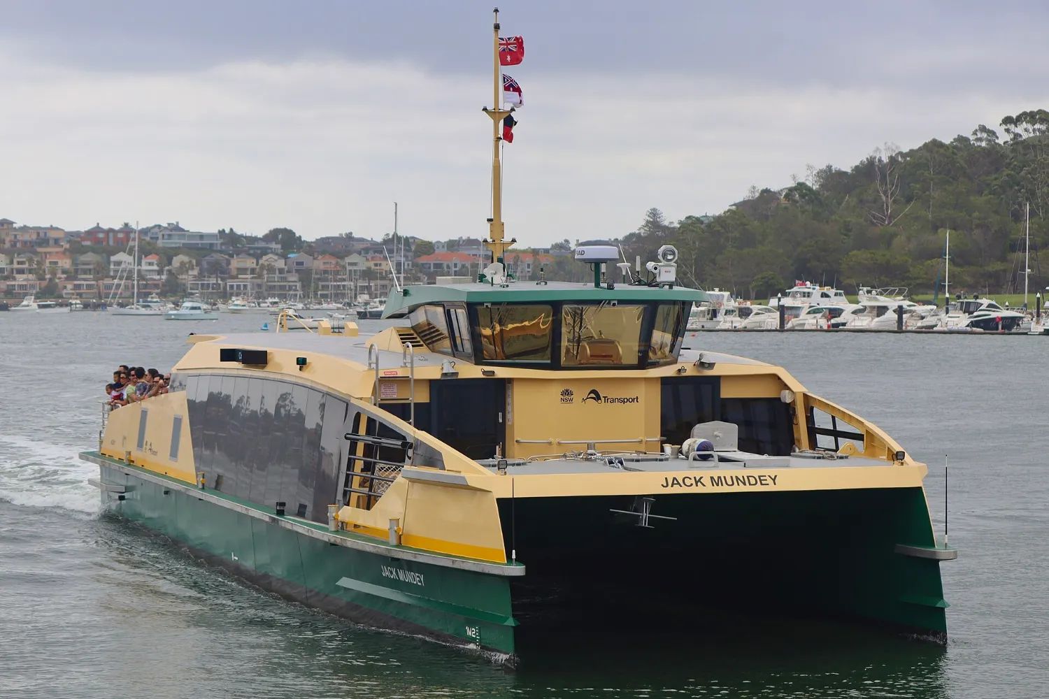 A green-and-yellow Sydney ferry on the harbour by Cockatoo Island