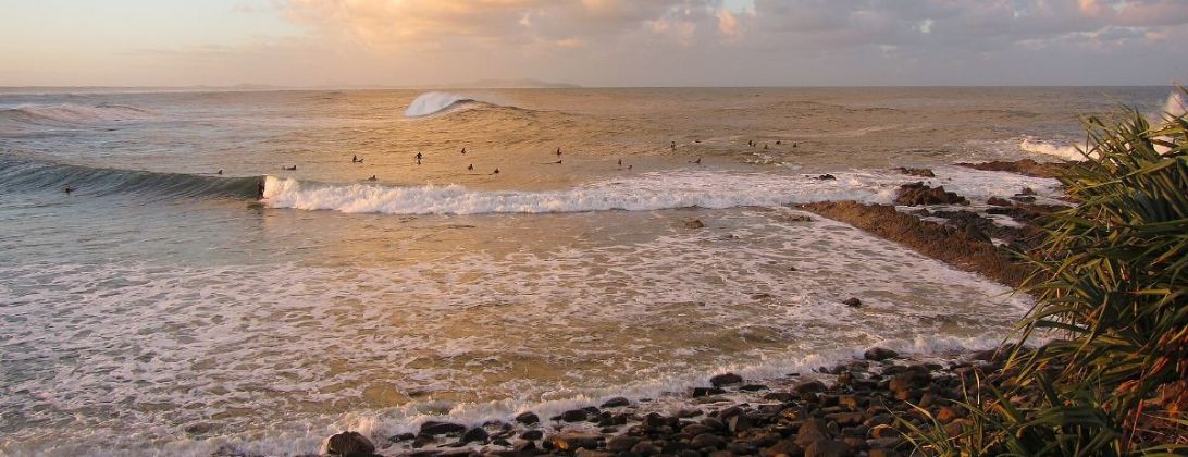 Surf breaking along the point at Crescent Head under a golden evening sky