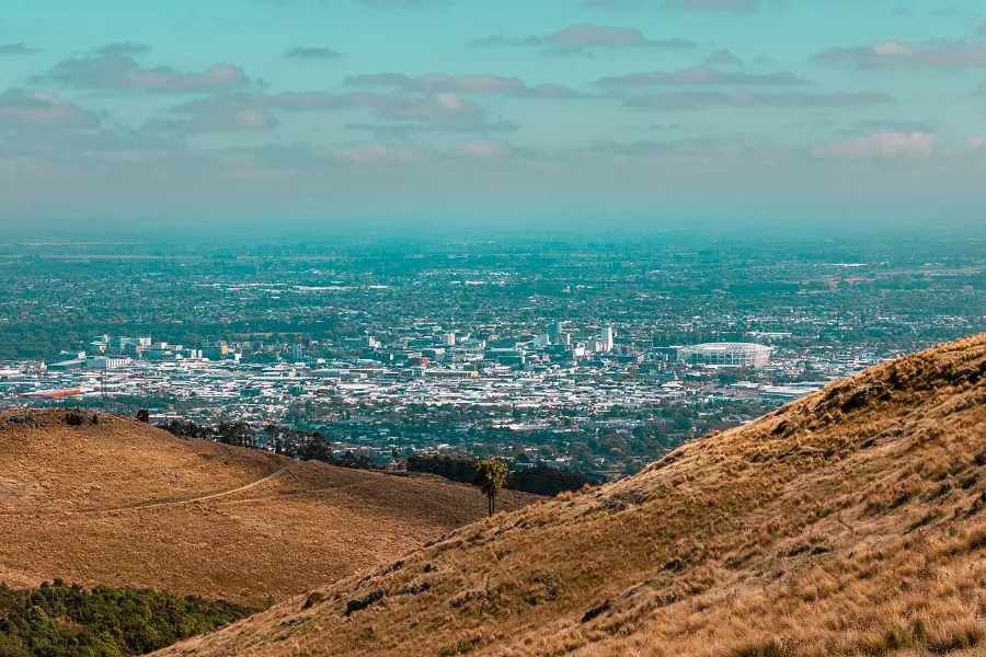 Christchurch spread across the flat Canterbury Plains, seen from the tawny slopes of the Port Hills.