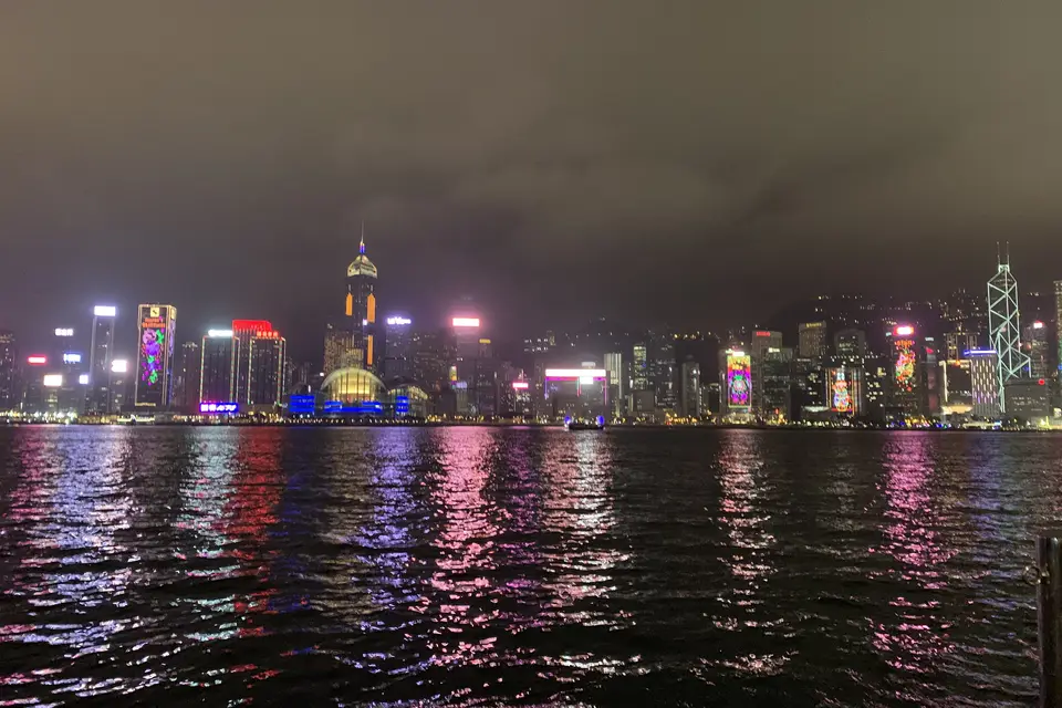 The lit Hong Kong Island skyline reflected in the harbour at night