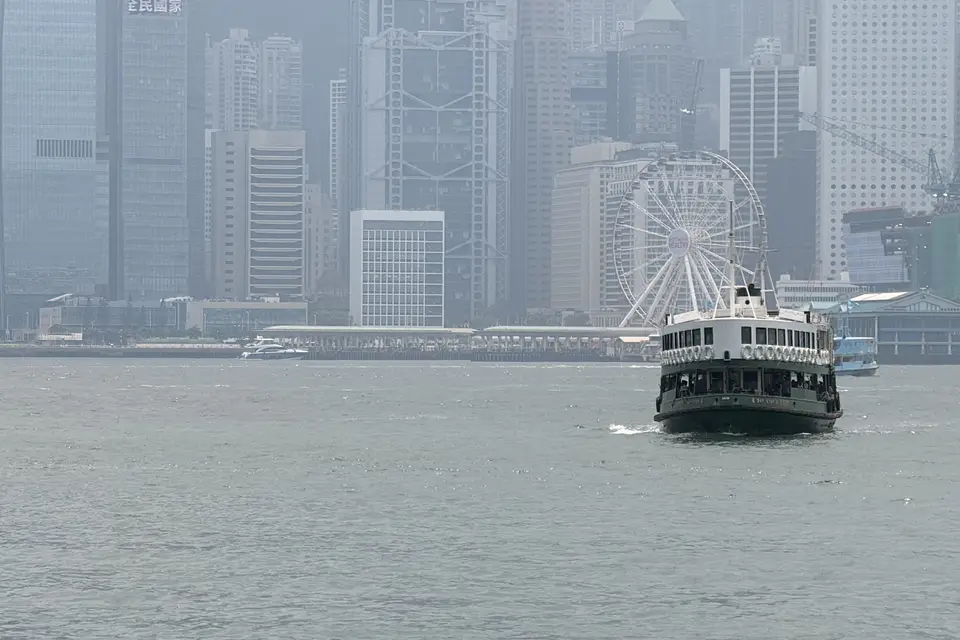 A Star Ferry crossing the harbour towards Central's towers