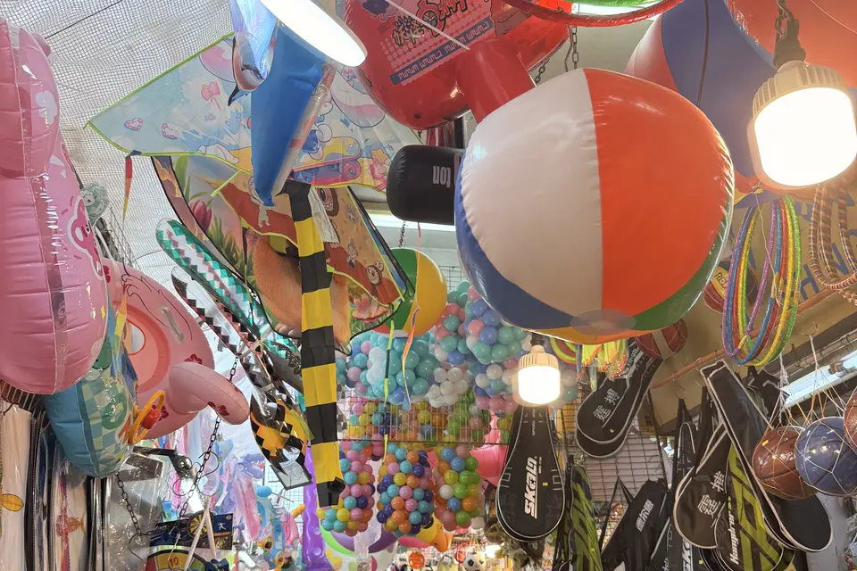 Inflatable toys and balls hanging over a Sham Shui Po stall