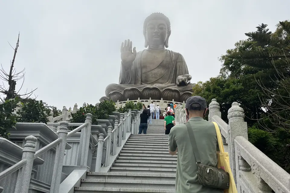 Visitors climbing the long stone stairway to the Tian Tan Buddha