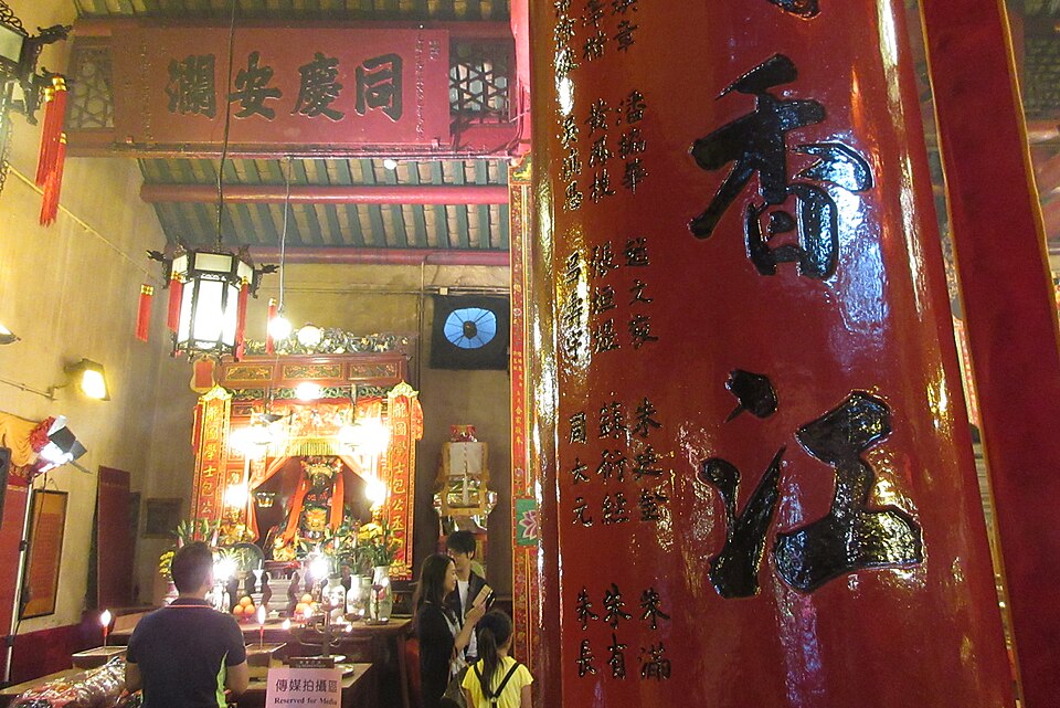 Inside Man Mo Temple, red pillars and incense in the low light
