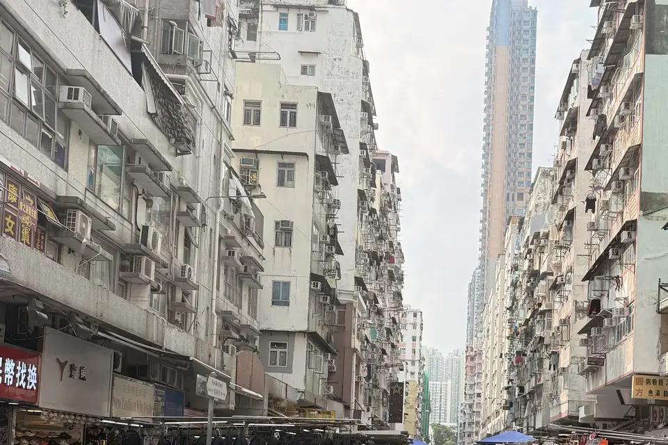 Tenement blocks crowding a Sham Shui Po market street