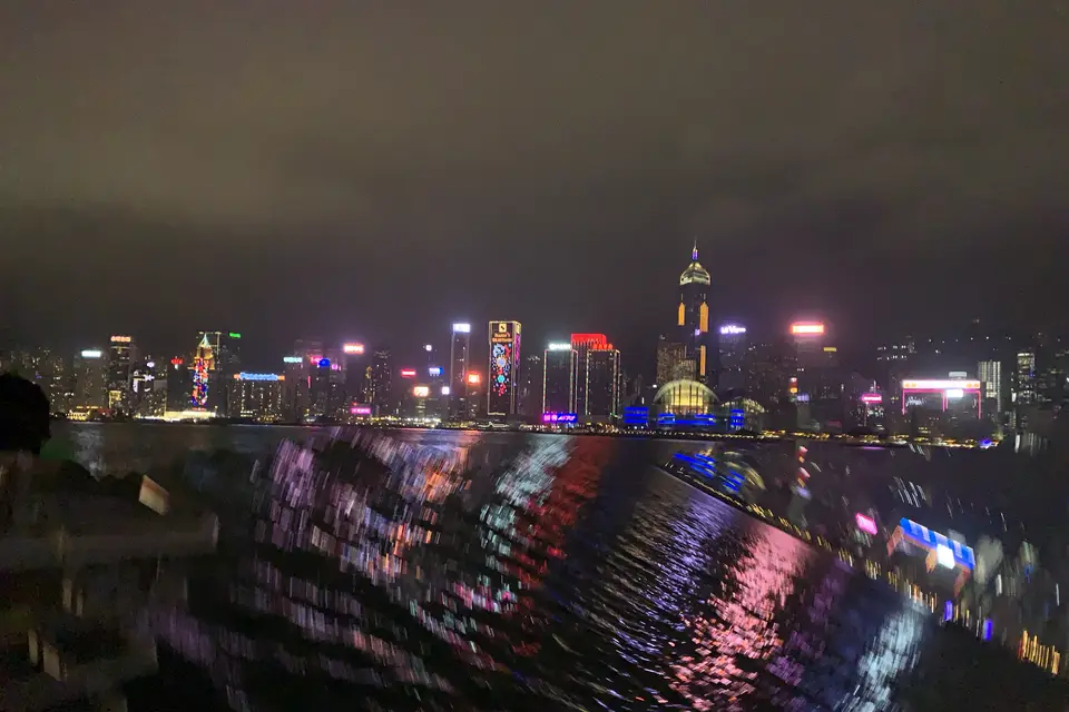 The lit Hong Kong Island skyline reflected in the harbour, from Tsim Sha Tsui