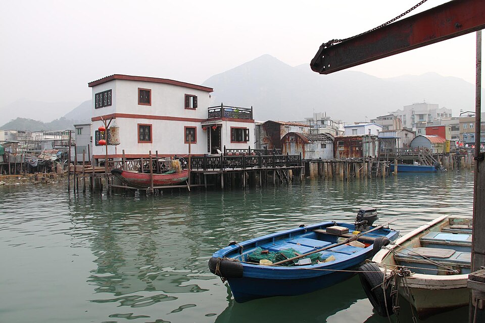 Stilt houses over the water at Tai O, with a small boat moored below
